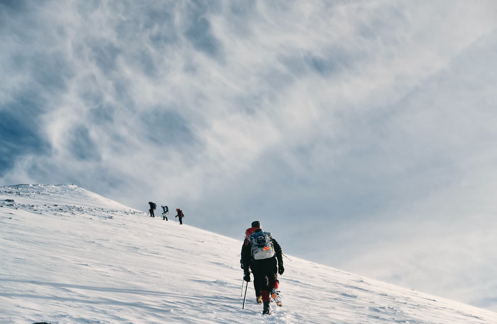 A field team ascending a snowy ridge.