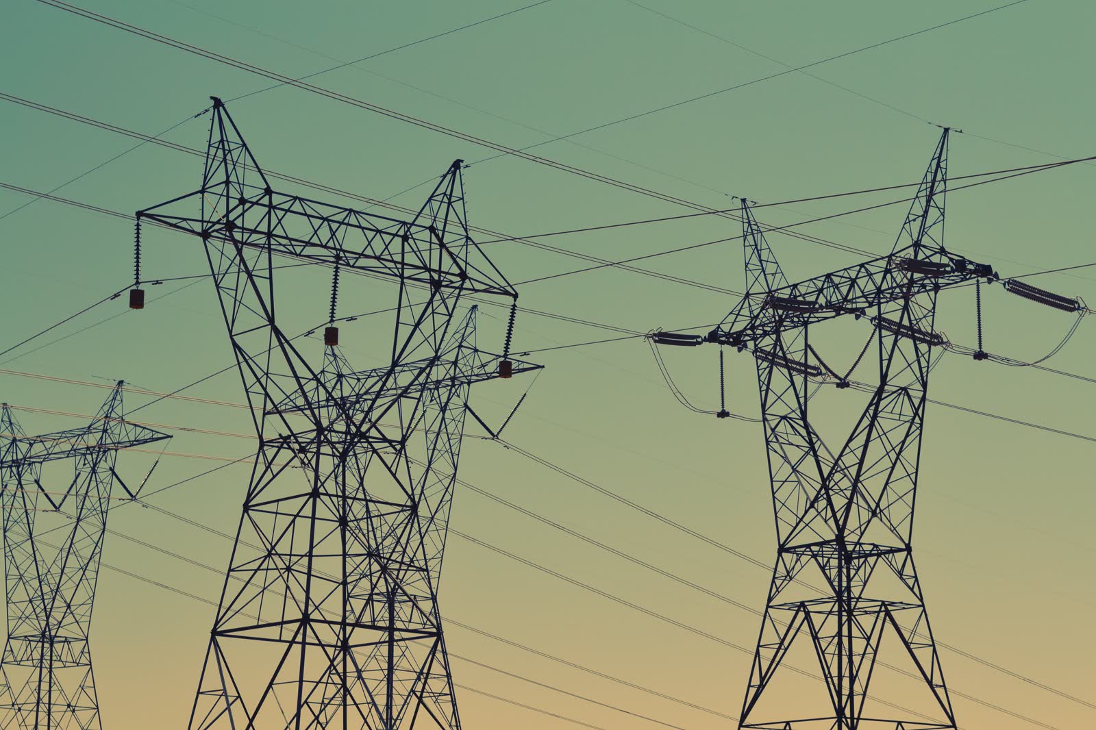 High-voltage transmission infrastructure at dusk.